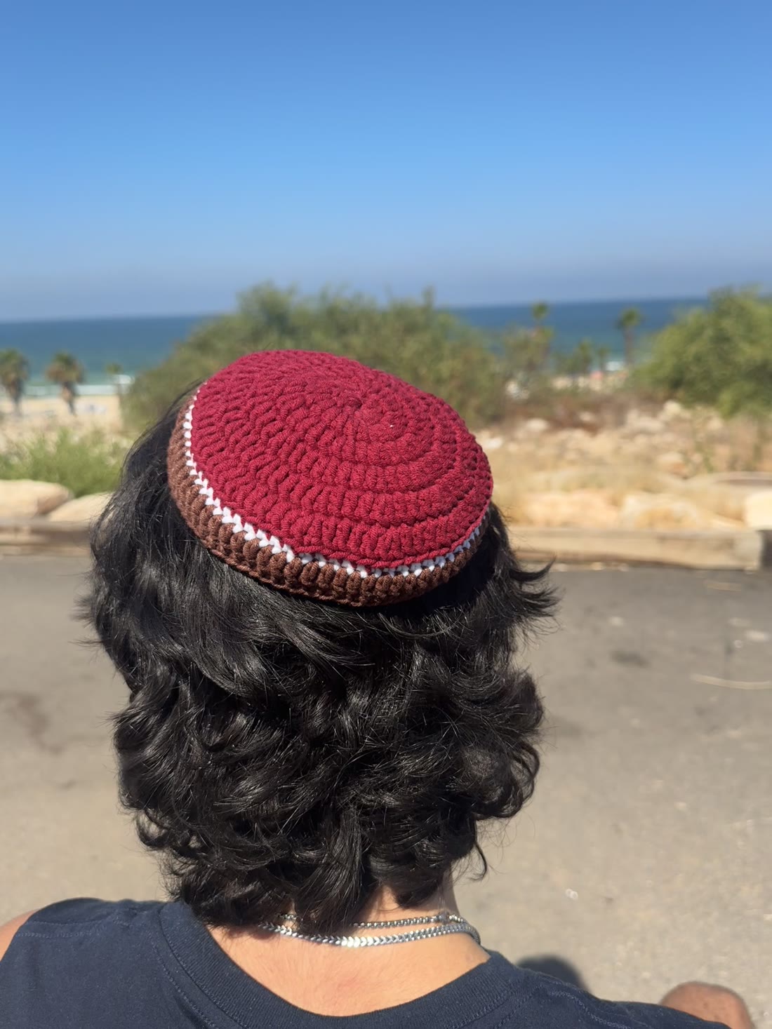 כיפה סרוגה בגוון בורדו עם פס חום ולבן, מעבודתה של מורן